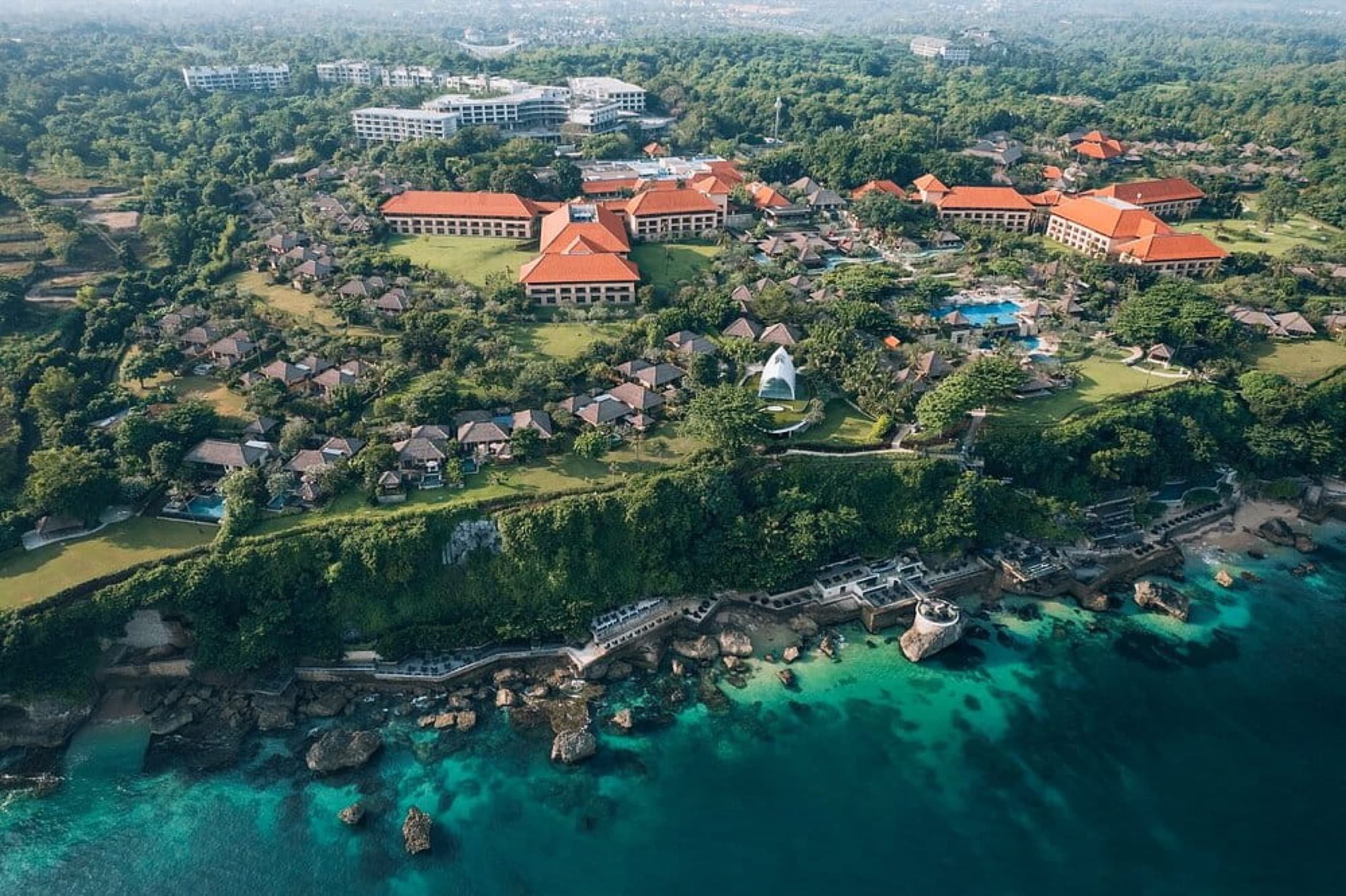 Aerial view of AYANA Resort's clifftop gardens, pools, and villas above the Bali coastline