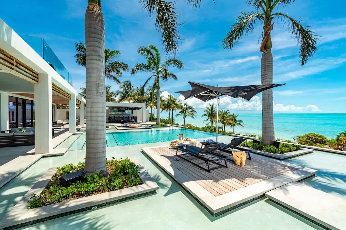 Oceanfront pool deck with palm trees at Grace Bay Club resort in Turks & Caicos